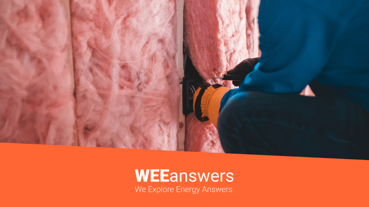 A energy efficiency contractor installs insulation in a home for better energy efficiency